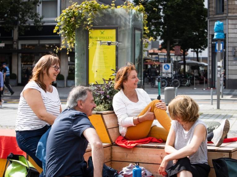 Menschen beim Picknick auf einem Platz.